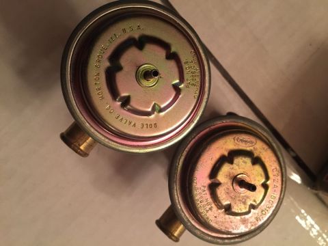1967 Mercury Cougar - Close-up of two vacuum diaphragms, one marked Dole Valve Co. and the other with a Ford logo.