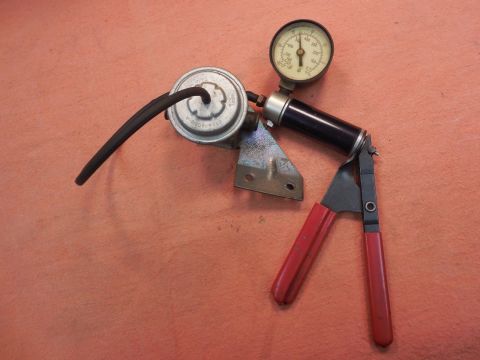 1967 Mercury Cougar - A vacuum gauge and pump assembly is shown with a red-handled tool attached.