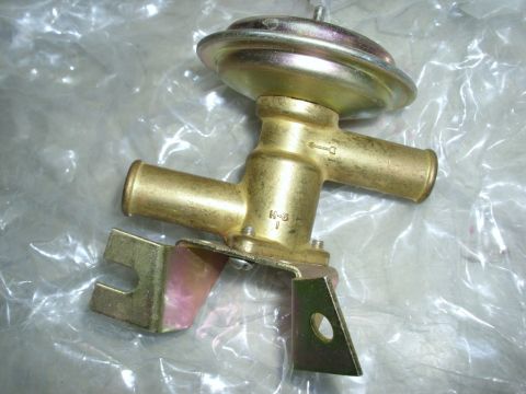 1967 Mercury Cougar - A brass heater control valve with a metal mounting bracket is shown against a plastic background.