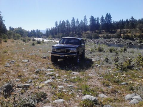 1995 Ford Bronco - This 1995 Ford Bronco is parked on a rocky, grassy area next to a river.