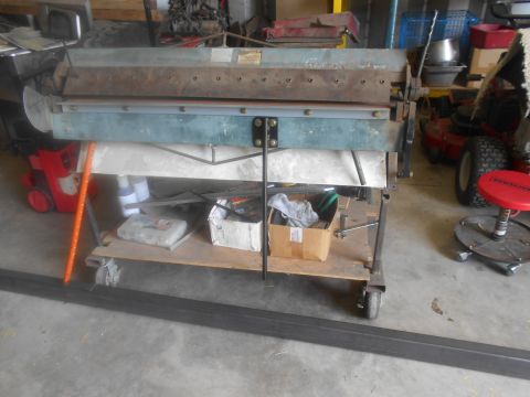 1992 Ford Bronco - A sheet metal brake is shown on a rolling cart, with various tools and supplies stored underneath.