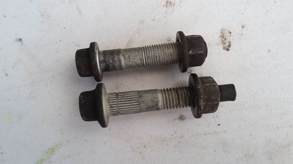 Two bolts with nuts on a white surface
