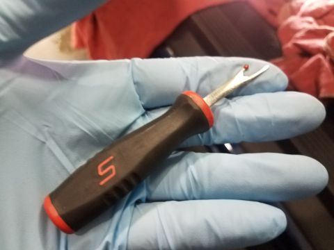 2003 Mercury Marauder - A trim removal tool with a red and black handle and a metal tip is held by gloved hands.