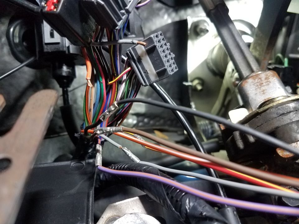Vehicle wiring harness with multiple colored wires and connectors, some exposed