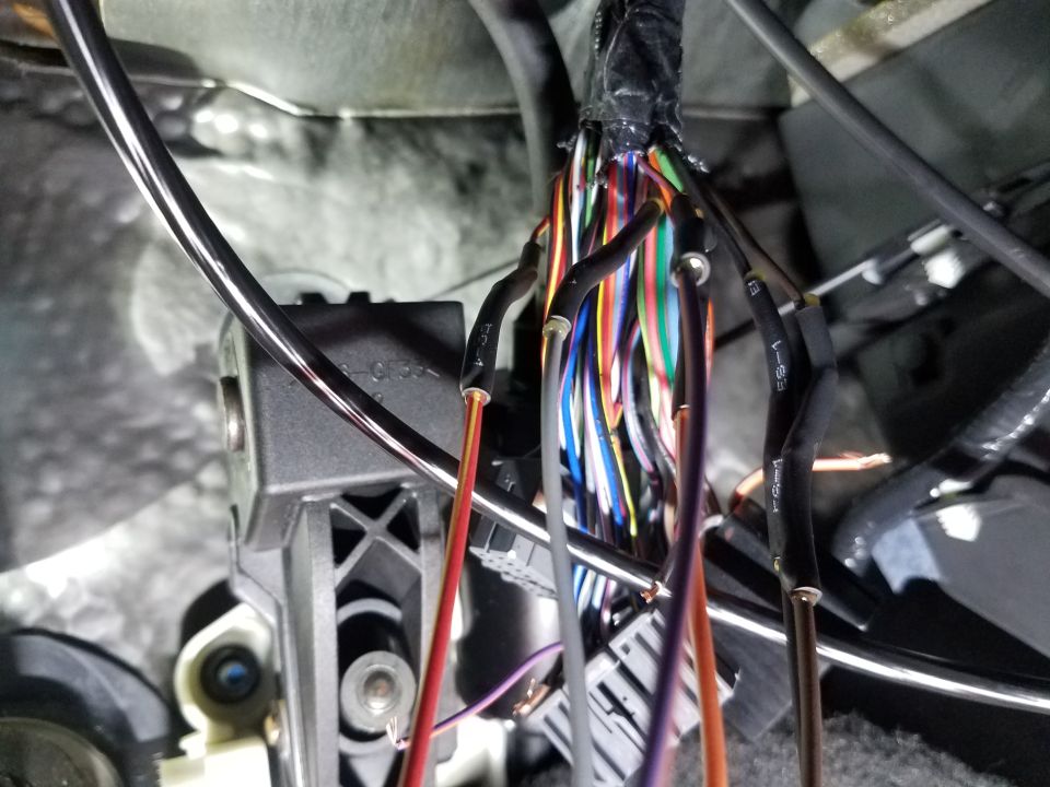 Close-up of a vehicle's wiring harness with many colored wires