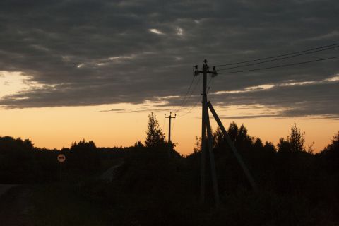 1993 Ford Bronco - A silhouette of telephone poles and trees against a dusky sky with orange and gray clouds.