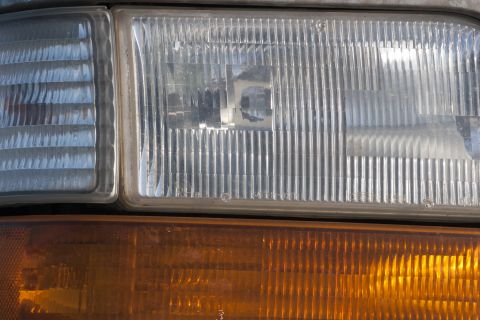 1993 Ford Bronco - A close-up view shows the clear headlight assembly above an amber turn signal assembly on a vehicle.