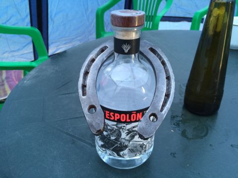 1993 Ford Bronco - A bottle of Espolon tequila is displayed on a table with a horseshoe around its neck. A dark green bottle is visible to the right of the te…