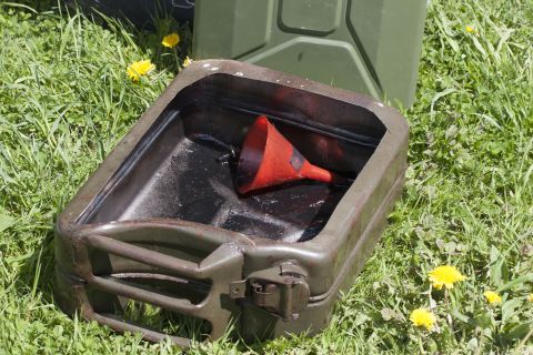 1993 Ford Bronco - An oil drain pan and funnel are placed on the grass beside a jerrycan.