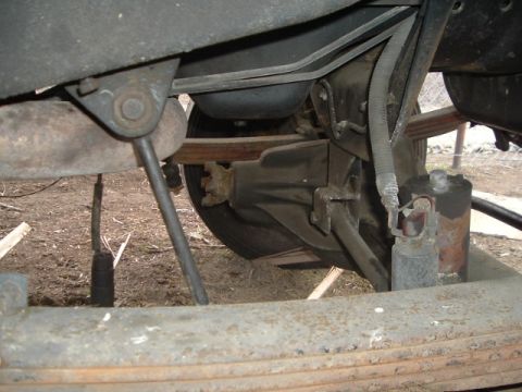 1987 Ford Bronco - Undercarriage view shows the rear axle assembly with leaf springs and a shock absorber.
