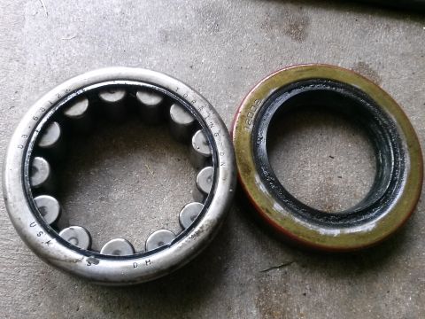 1996 Ford Bronco - A roller bearing with 'DB 6 8126' and 'USA' stamped on the outer race is shown next to a red and green seal with '12002' stamped on it. Bot…