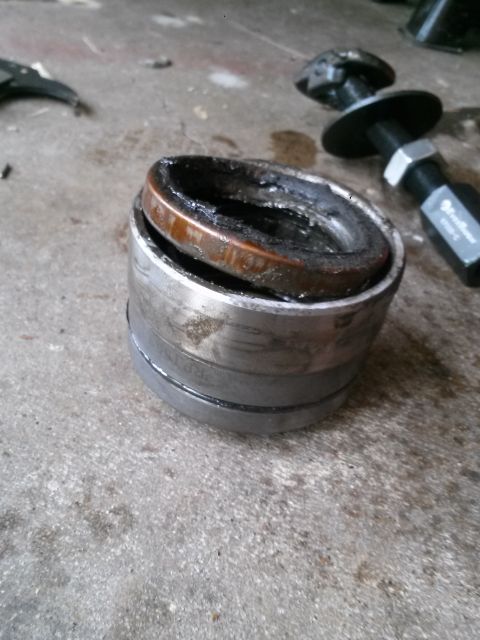 1996 Ford Bronco - A close-up shot shows a worn and greasy bearing assembly, likely removed from a vehicle component. The metal parts are discolored with rust…