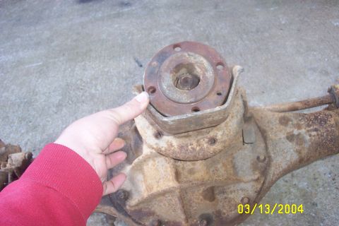 1979 Ford F-150 - A close-up view of a rusty differential axle housing, with a hand indicating the yoke flange.