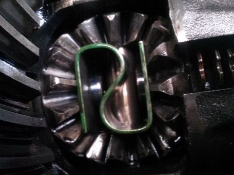 1996 Ford Bronco - A close-up view of a differential with a green clip inserted into the gears. The gears appear to be part of a vehicle's drivetrain.