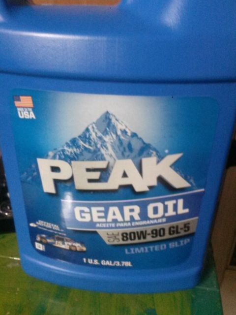 1996 Ford Bronco - A blue plastic jug of Peak Gear Oil is shown. The label features a mountain range and text indicating "80W-90 GL-5 LIMITED SLIP".