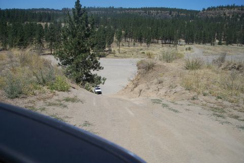 1995 Ford Bronco - Off-road trail scene with dry vegetation and hills in the background.