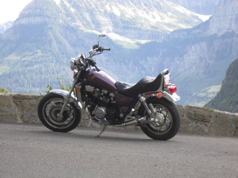 1974 Ford Ranchero - A purple motorcycle is parked on the side of a mountain road with a scenic mountain range in the background.