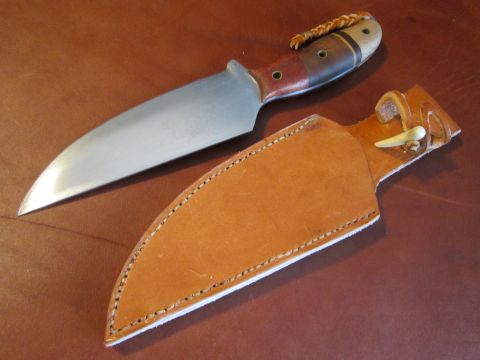 1974 Ford Ranchero - A handmade knife with a polished steel blade and a multi-wood handle is shown next to a tan leather sheath with a bone toggle.