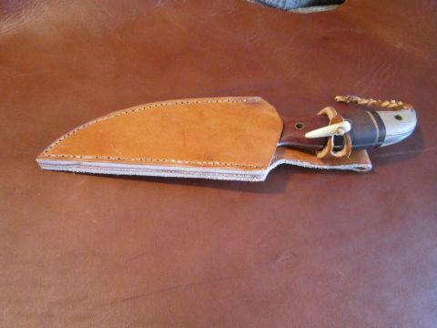 1974 Ford Ranchero - A leather knife sheath with a knife partially inserted is shown against a brown leather background.