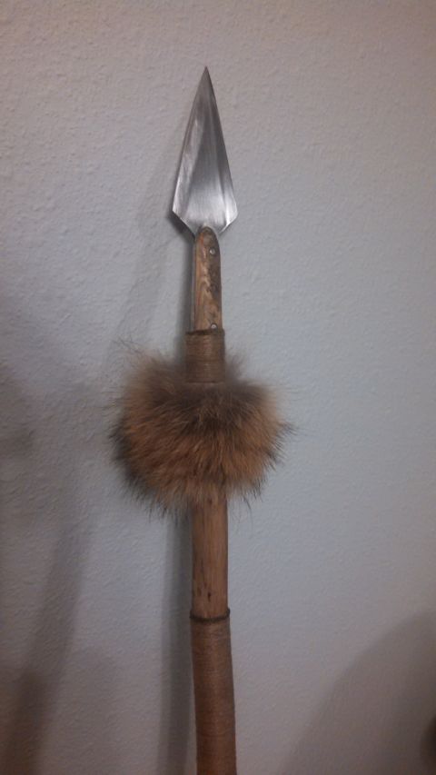 1974 Ford Ranchero - A close-up view of the arrowhead and shaft of a spear, decorated with a band of brown fur.