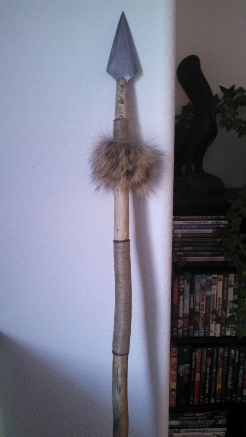 1974 Ford Ranchero - A close-up of a spear with a metal arrowhead, fur trim, and a wooden shaft wrapped in twine. The spear is standing upright against a white…