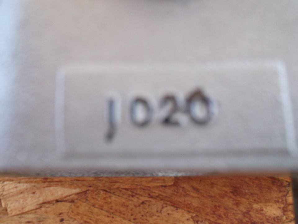 Close-up of a part with embossed numbers 'J020'