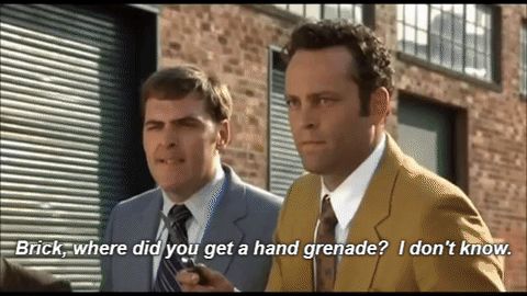1995 Mercury Grand Marquis - Movie screen grab used as a reaction image: two men in 1970s-style suits stand in front of a brick building and roll-up door, with subtitle…