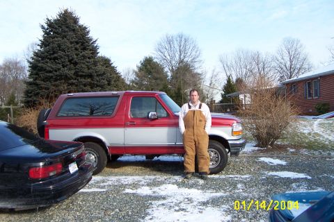 1996 Ford Bronco - A man poses with his red and silver Ford Bronco in a snowy driveway next to a black car.