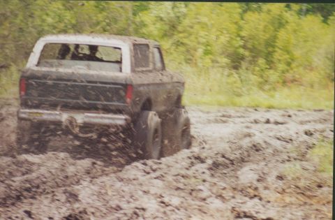 1993 Ford Bronco - This SUV is stuck deep in the mud, with its rear end partially submerged.