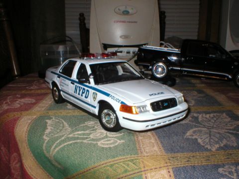 1989 Ford Crown Victoria - Model of a 1989 Ford Crown Victoria police car with NYPD markings sits on a patterned surface.