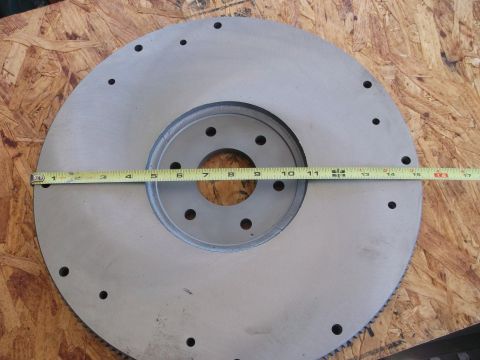 1963 Ford Galaxie - A metal flywheel is shown with a tape measure laid across it for size reference.