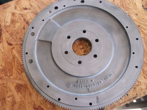 1963 Ford Galaxie - A metal Ford flywheel with a toothed outer edge and multiple bolt holes is shown.