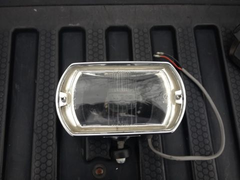 1968 Mercury Cougar - This headlight assembly, likely an aftermarket part, is shown resting on a dark, textured surface.