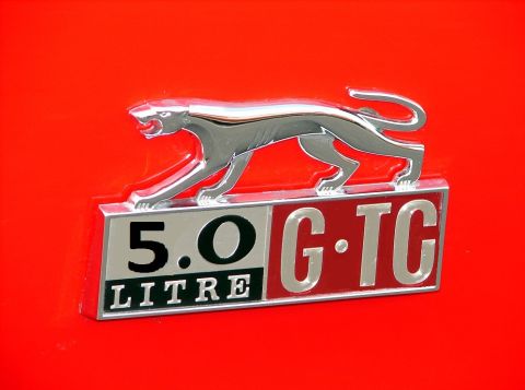 1968 Mercury Cougar - A chrome cougar emblem and "5.0 G-TC LITRE" badge are affixed to a red vehicle surface.