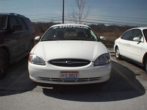 1999 Ford Taurus - Front view of a white Ford Taurus, showing its grille, headlights, and license plate.