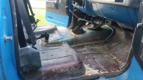 1978 Chevrolet C/K Pickup - The interior floor of the truck shows signs of wear and some debris scattered around.