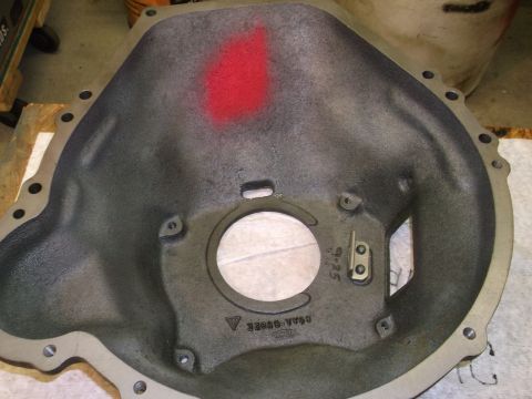 1963 Ford Galaxie - Close-up of a vehicle bell housing part, showing casting marks and a red spray paint indicator.