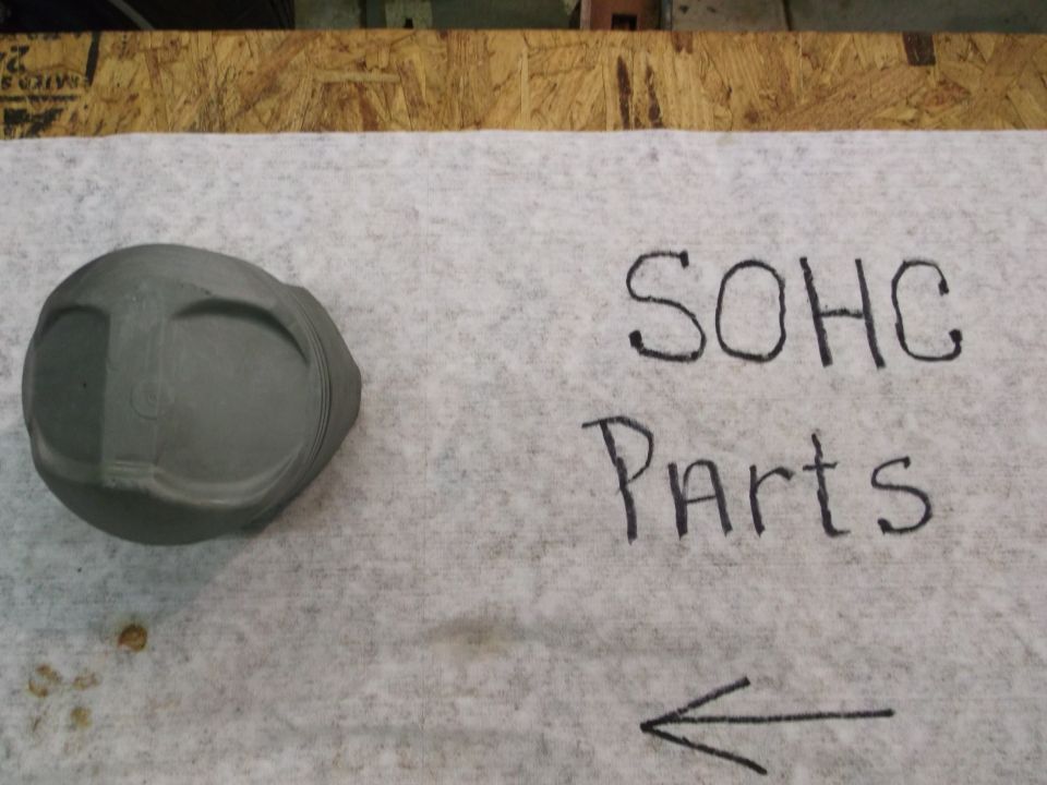 SOHC parts written next to a piston on a white cloth