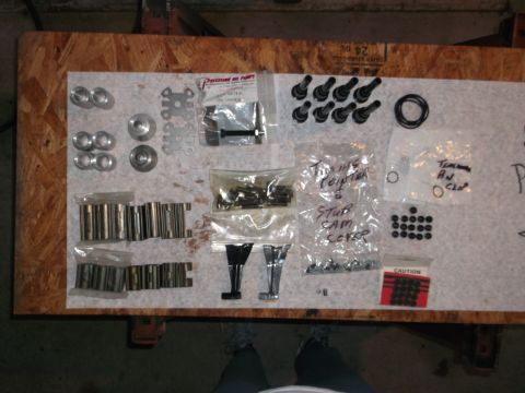 1963 Ford Galaxie - Various engine components are organized on a workbench for inspection or assembly.