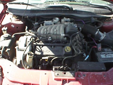 1999 Ford Taurus - Close-up of the engine compartment of a 1999 Ford Taurus, showing the 3.0L V6 engine.