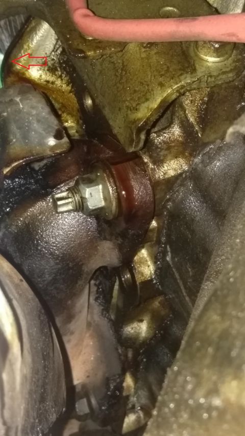 2000 Ford Crown Victoria - Close-up view of an engine component showing a bolt and signs of fluid leakage.