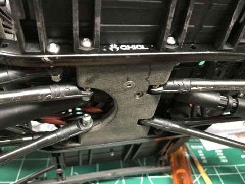 1989 Ford Bronco - Close-up view of the underside of an RC car chassis, showing suspension components and the "AXIAL" manufacturer logo.