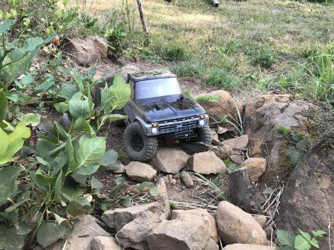 1989 Ford Bronco - A remote-controlled truck navigates a rocky outdoor terrain.