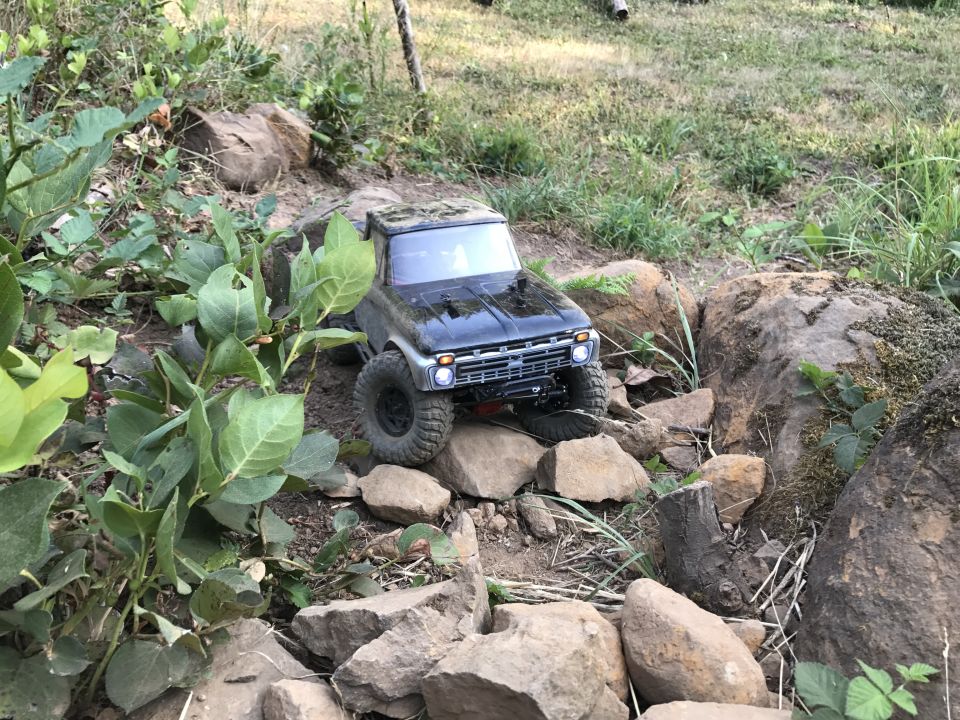 RC truck with large tires crawling over rocks and dirt