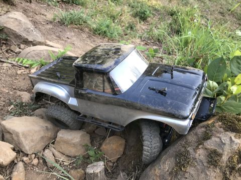 1989 Ford Bronco - This remote-controlled truck is navigating a challenging, rocky outdoor course.