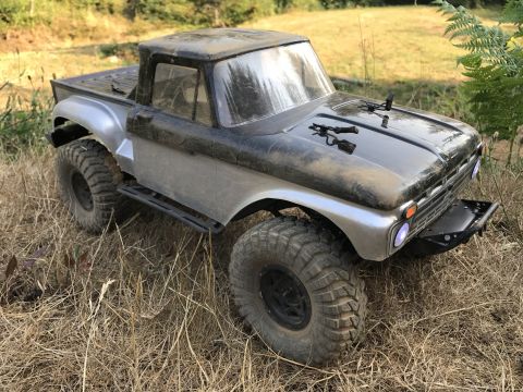 1989 Ford Bronco - This remote control truck, resembling an older model pickup, is parked on dry grass.