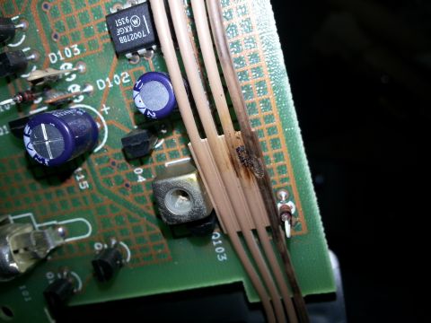1994 Ford Bronco - A close-up view of a damaged electronic circuit board shows signs of burning on the wires and components.