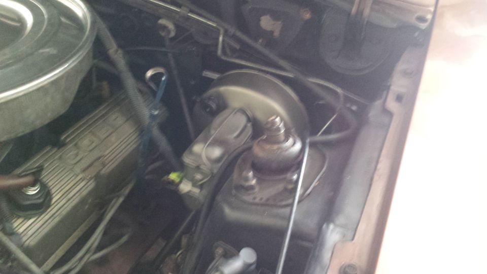 engine bay showing brake booster, master cylinder, and part of valve cover