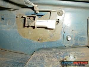 1994 Ford Bronco - Close-up of a vehicle's tailgate latch mechanism, with visible metal and rubber parts.