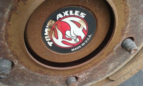 1995 Ford Bronco - Close-up of a rusty hubcap with the Tom's Axles logo and 'Made in U.S.A.' text visible.